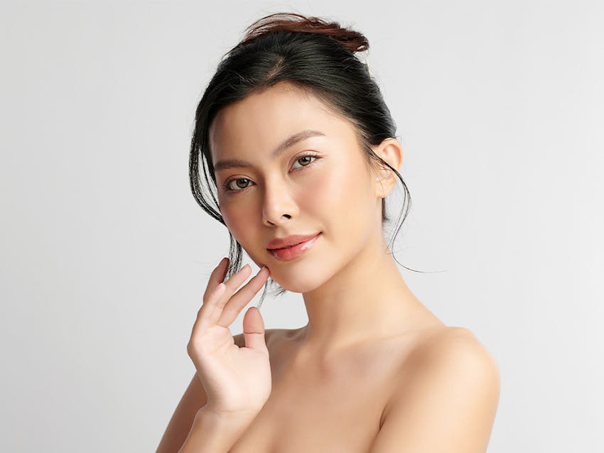 woman with hand touching her face