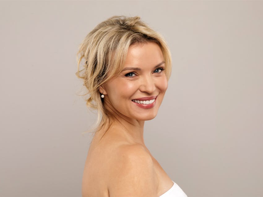 blonde woman turing to camera smiling