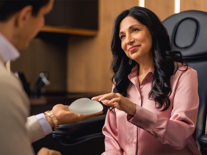 female patient touching breast implant