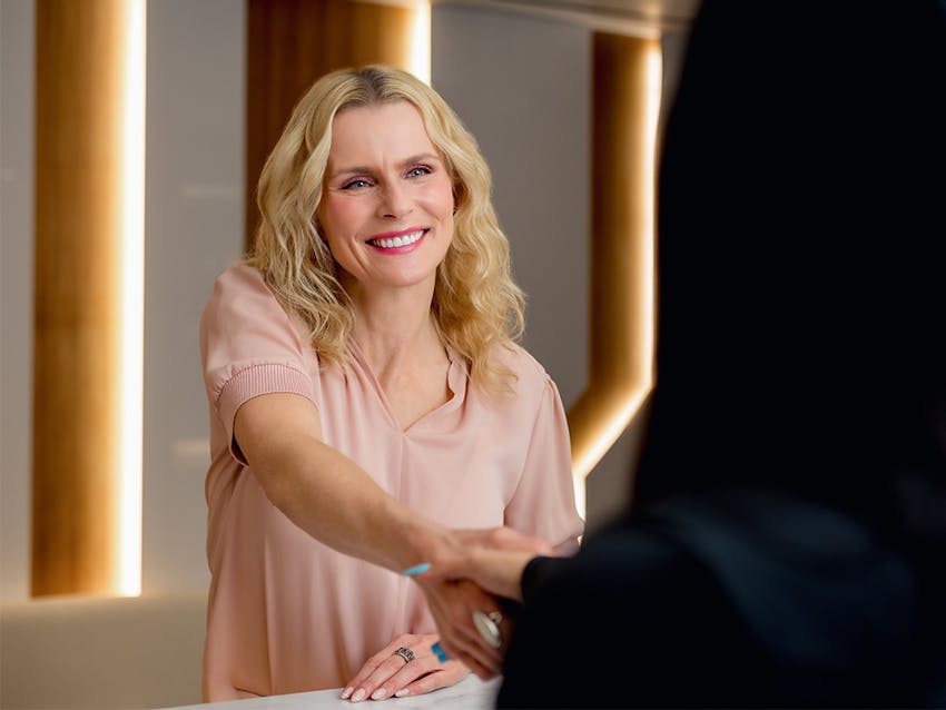 female patient shaking receptionists hand