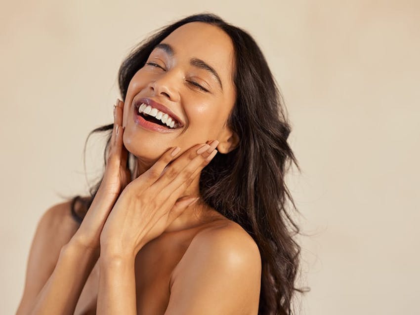 Woman touching her face and smiling