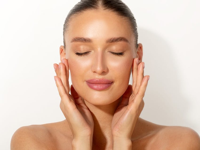 woman touching her face with both hands