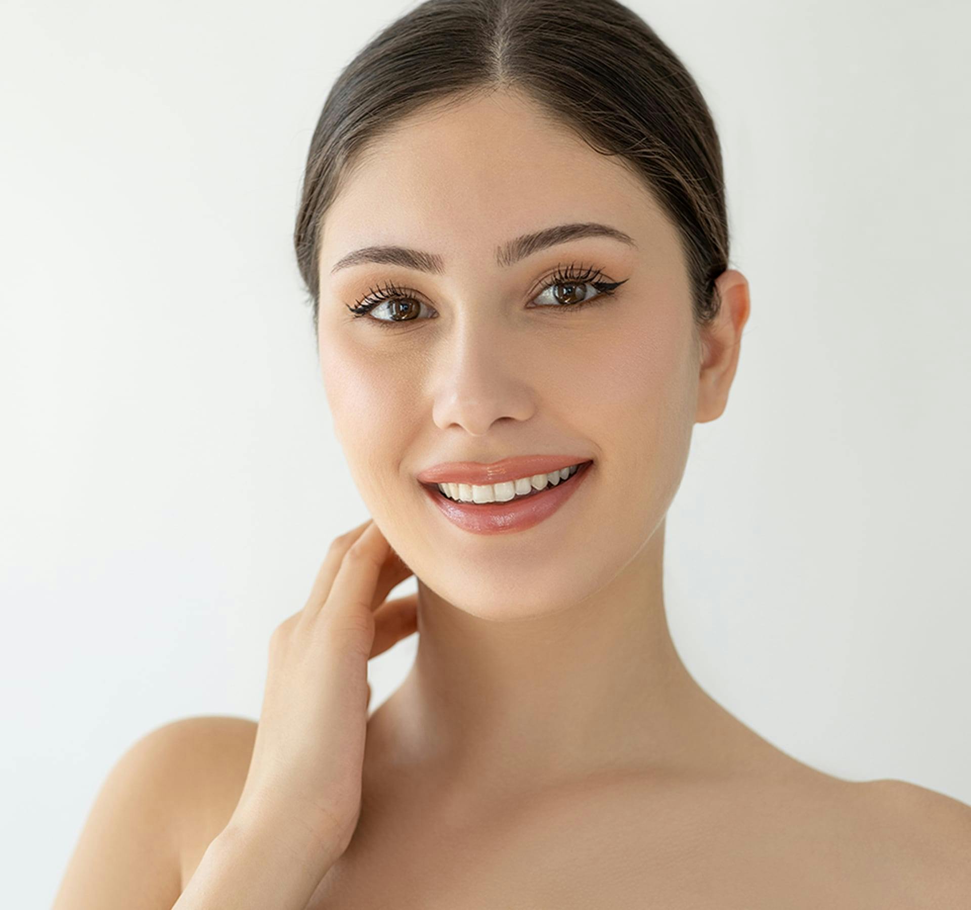 woman smiling with her hand on her neck
