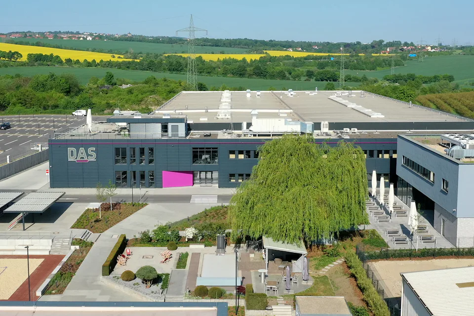 graues Gebäude mit Bäumen und Wegen