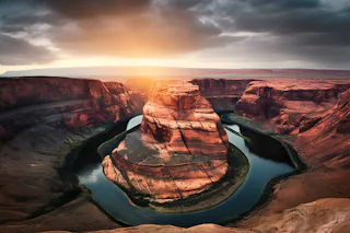 River in the desert A breathtaking view of Horseshoe Bend at sunset, where the Colorado River elegantly curves around a monumental sandstone rock formation, under a dramatic, cloud-filled sky.
