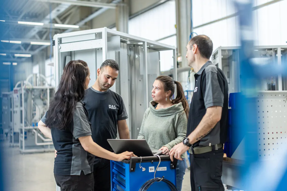 Our teams in Dresden working closely for best customer experience team of four standing in manuacturing environment