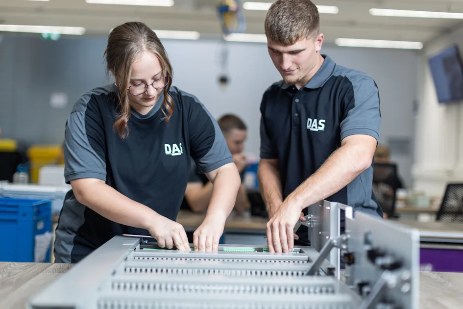 Precision Manufacturing: Our experts assembling electronic components Two skilled workers in assembly focus intently on a complex industrial assembly task, promoting young talent within the manufacturing production team.