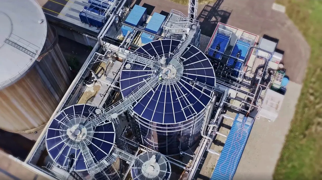 DSM Referenz Vogelperspektive Luftaufnahme einer industriellen MBBR-Anlage mit mehreren großen, kreisförmigen Klärbehältern, umgeben von Rohrleitungen und Maschinen in einem industriellen Komplex.