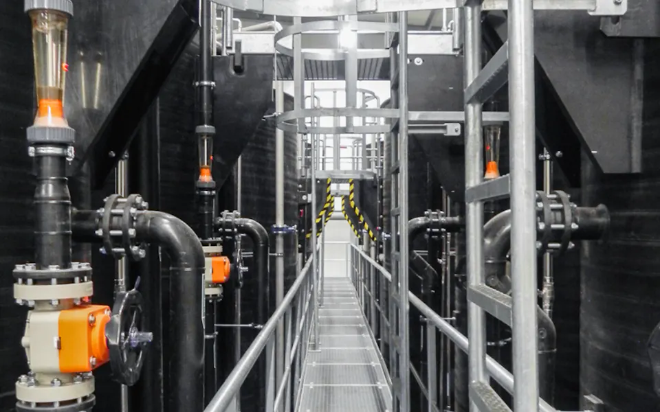 Kesslergrube 표지 청정한 공장 환경 내에 밸브와 파이프로 둘러싸인 금속 통로가 있는 최첨단 산업용 배관 시스템.