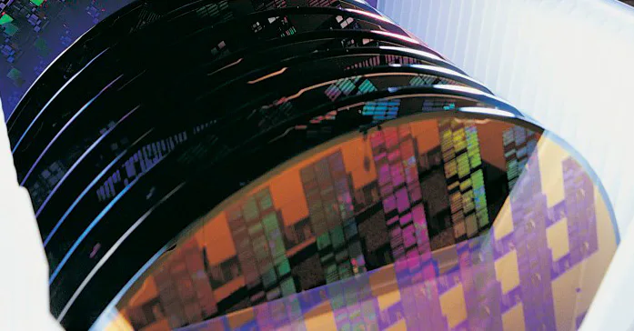 Silicon wafers A stack of colorful silicon wafers with intricate patterns is shown, highlighting the precision and complexity of semiconductor technology.