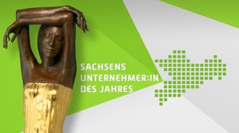 A bronze statue with arms raised overhead stands against a green and white background, accompanied by the text "Sachsens Unternehmer:in des Jahres" and a pixelated map outline.