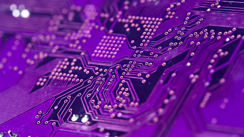 MEMS A close-up view of a purple printed circuit board showcasing complex electronic pathways and numerous copper connectors.