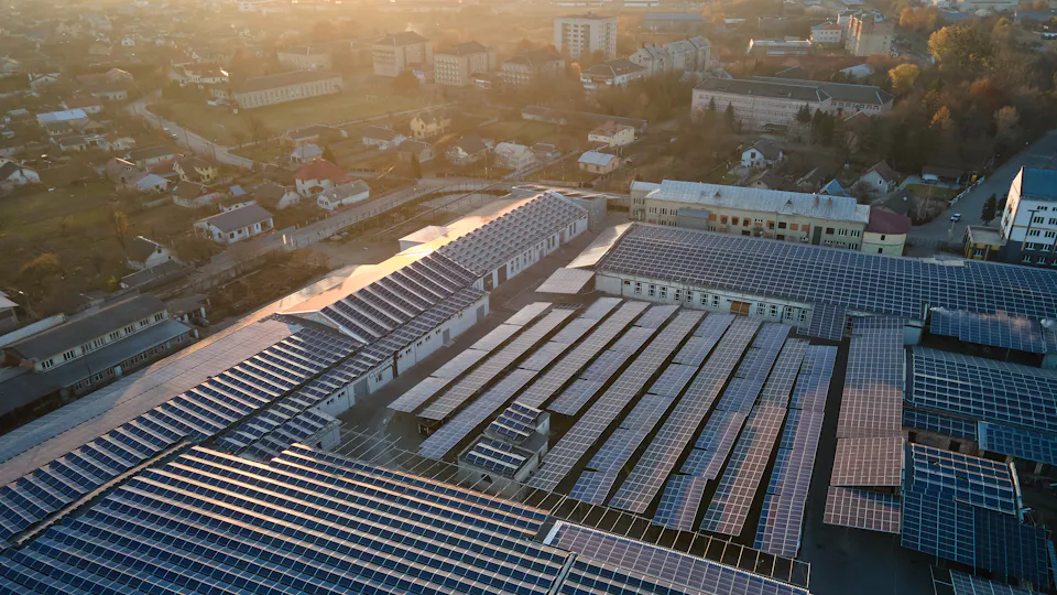 太陽能產業 日落時分的城市景觀下太陽能電池板覆蓋的大片工業區域,展示可再生能源的應用和環保發電解決方案。