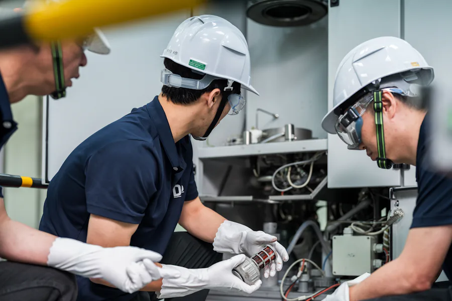Tool Checking 工人們戴著頭盔和護目鏡,身穿制服,在工廠車間內進行機器設備的檢查和維護。