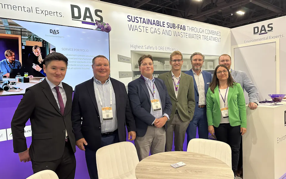 Impressions SEMICON West A group of people is standing in a business exhibit booth featuring a display about "Sustainable Sub-Fab Through Combined Waste Gas and Wastewater Treatment" by DAS Environmental Experts, with a modern design, informational banners, and a round table in the foreground.