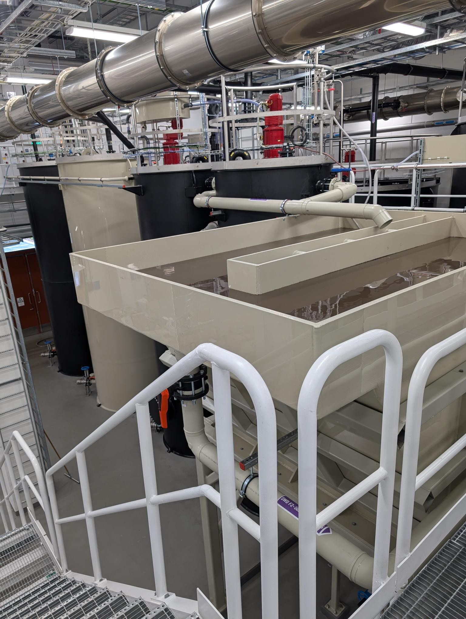 A large industrial water treatment system with pipes and tanks in a modern facility, designed for efficient filtration and purification processes.