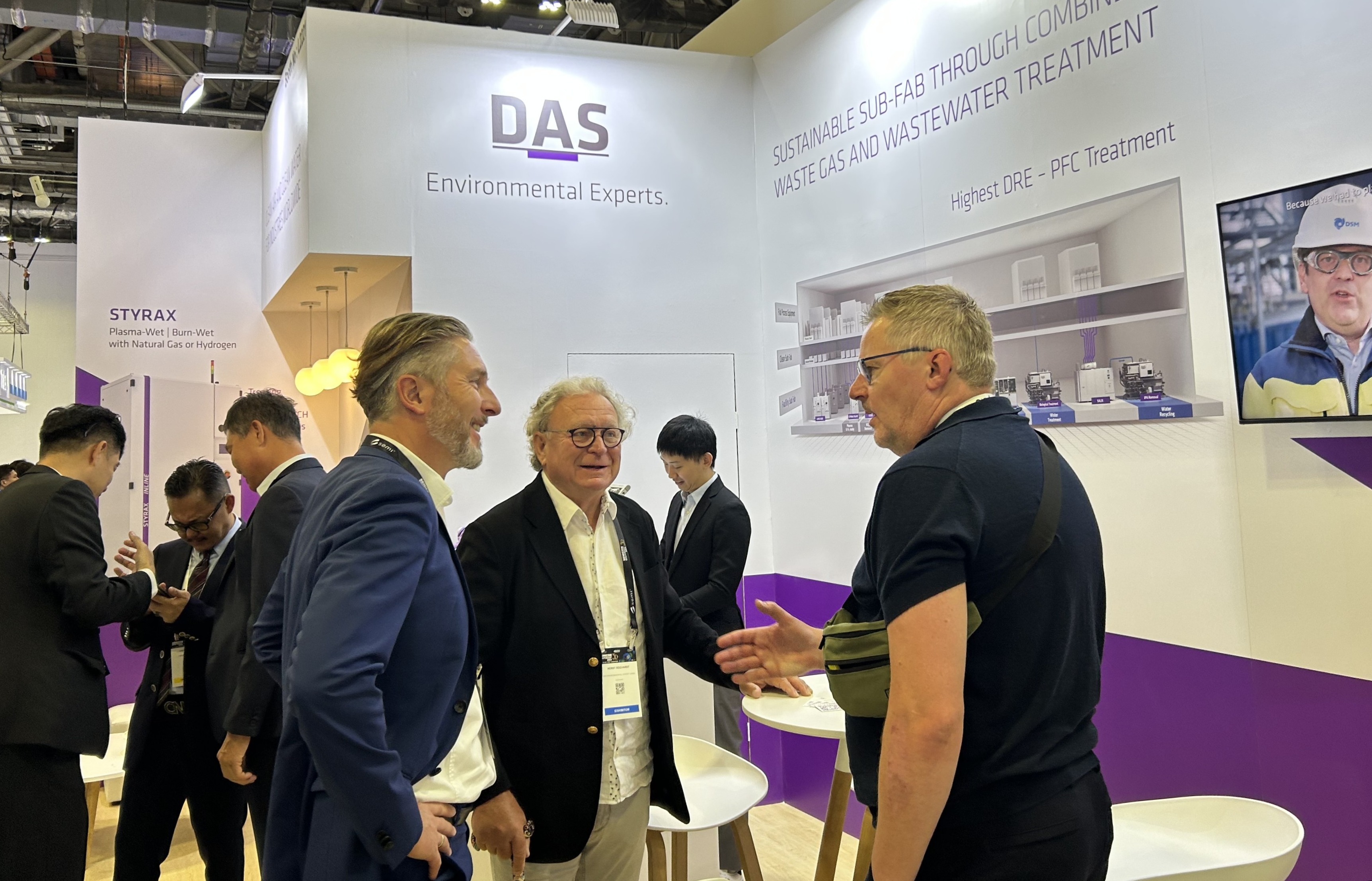 An einem gut besuchten Messestand unterhalten sich mehrere Fachleute unter einem Schild mit der Aufschrift „DAS Environmental Experts“ und präsentieren nachhaltige Lösungen für die Gas- und Abwasserbehandlung.