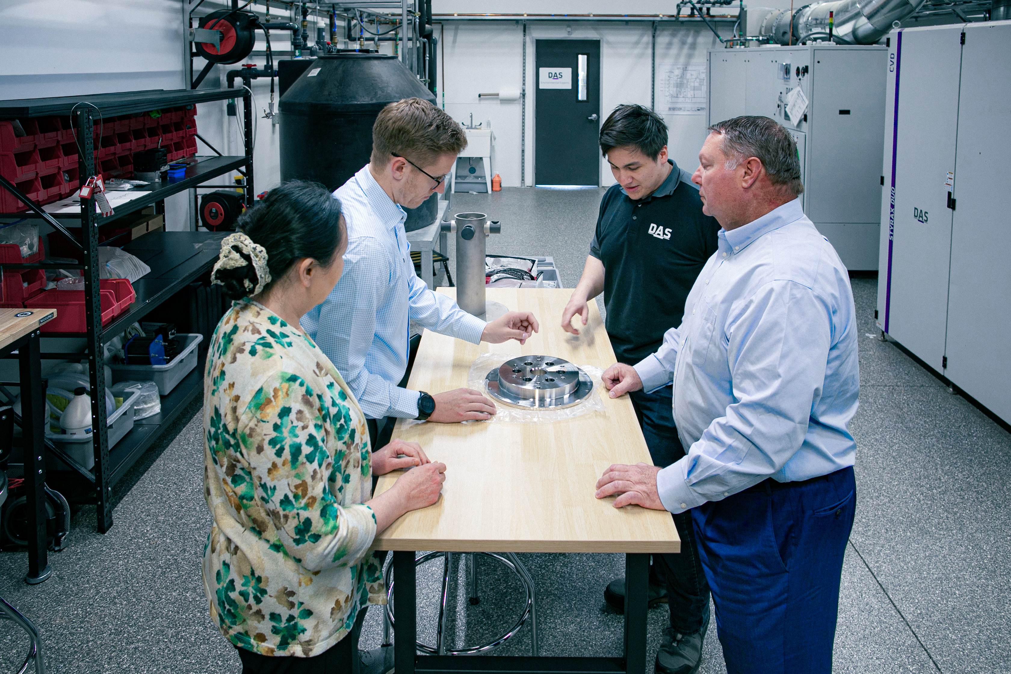 Employees in a technical discussion standing around a table
