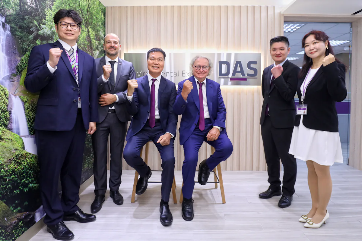 新竹辦公室開幕 圖片顯示六位穿著正式商務裝的人在專業的辦公環境中,背景牆上有公司標誌,其中一人坐著,其他人站在旁邊;大家擺出握拳姿勢,展現團結與自信。