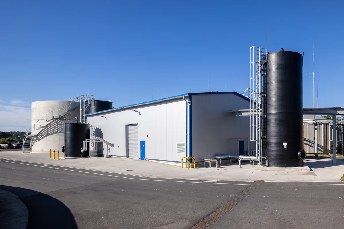 Emsland Aller Aqua The image depicts a modern industrial facility with large cylindrical storage tanks and a white building, under a clear blue sky.