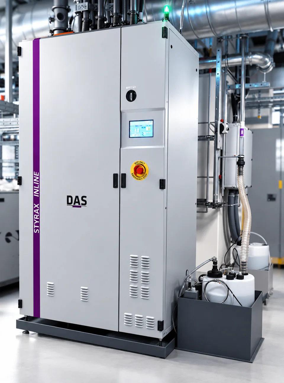 A large industrial machine labeled DAS  STYRAX Inline stands in an industrial environment, featuring a central control panel with a digital display and various connected tubes and wiring, exemplifying modern industrial equipment.