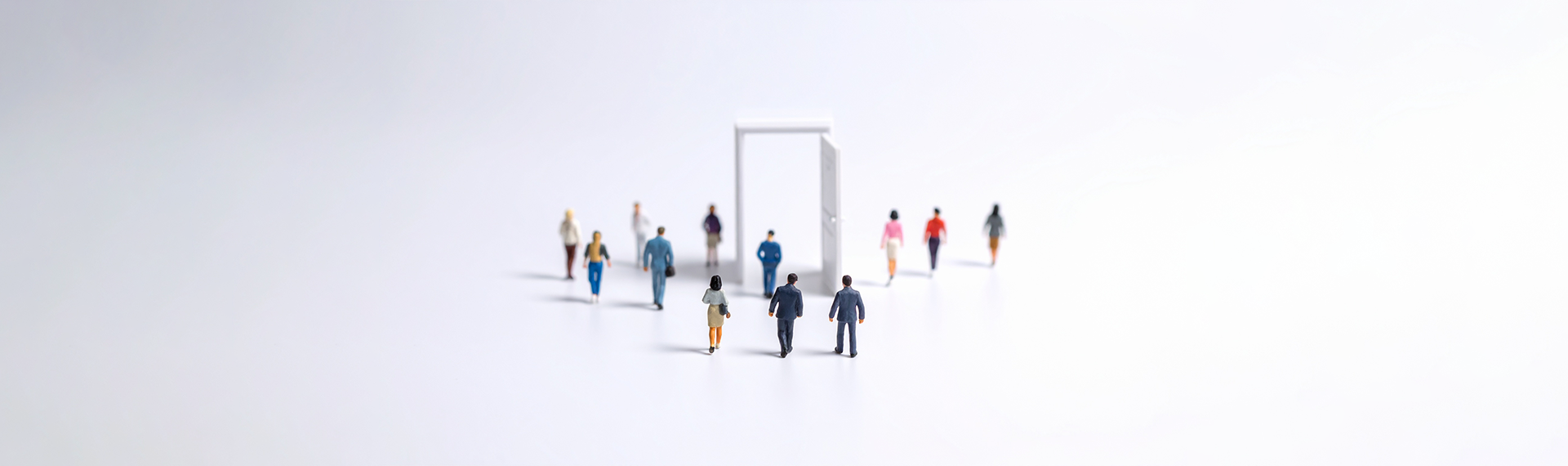 a group of miniature figurine people walking through an open door, signalling the change of Windows 10 to Windows 11