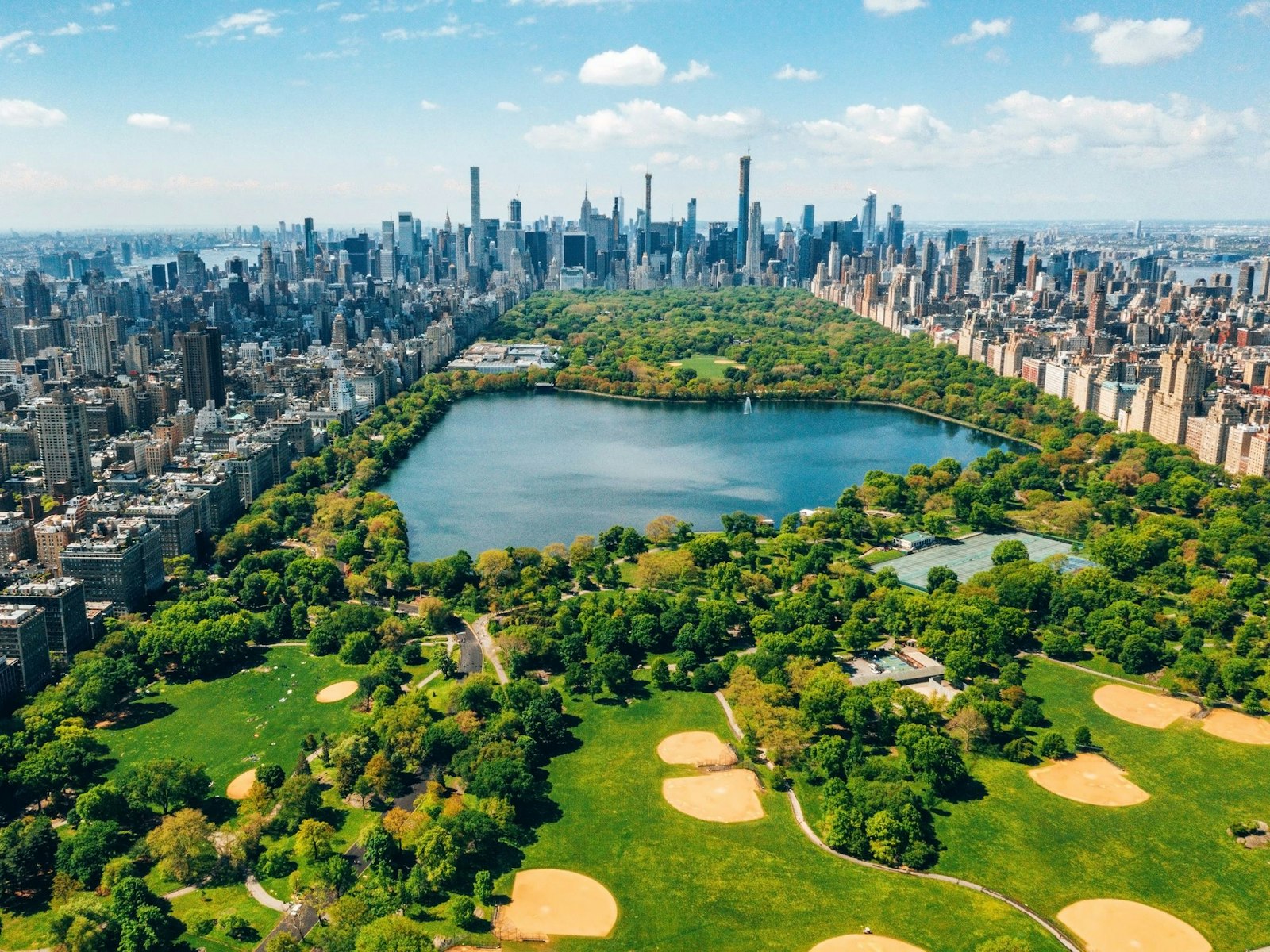 Aerial view of Central Park with golf courses and tall skyscrapers surrounding the park.