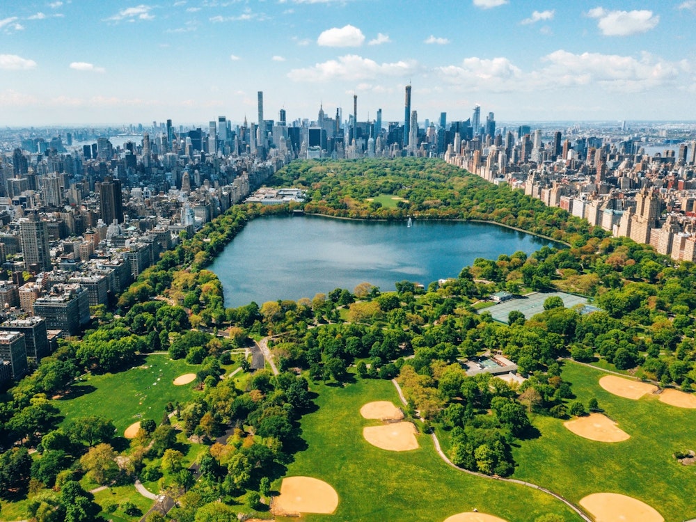 Vue aérienne de Central Park avec des terrains de golf et de grands gratte-ciel entourant le parc.