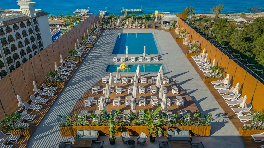 Rooftop pool terrace behind tall privacy screens, with the sea beyond, at Bera Alanya Resort
