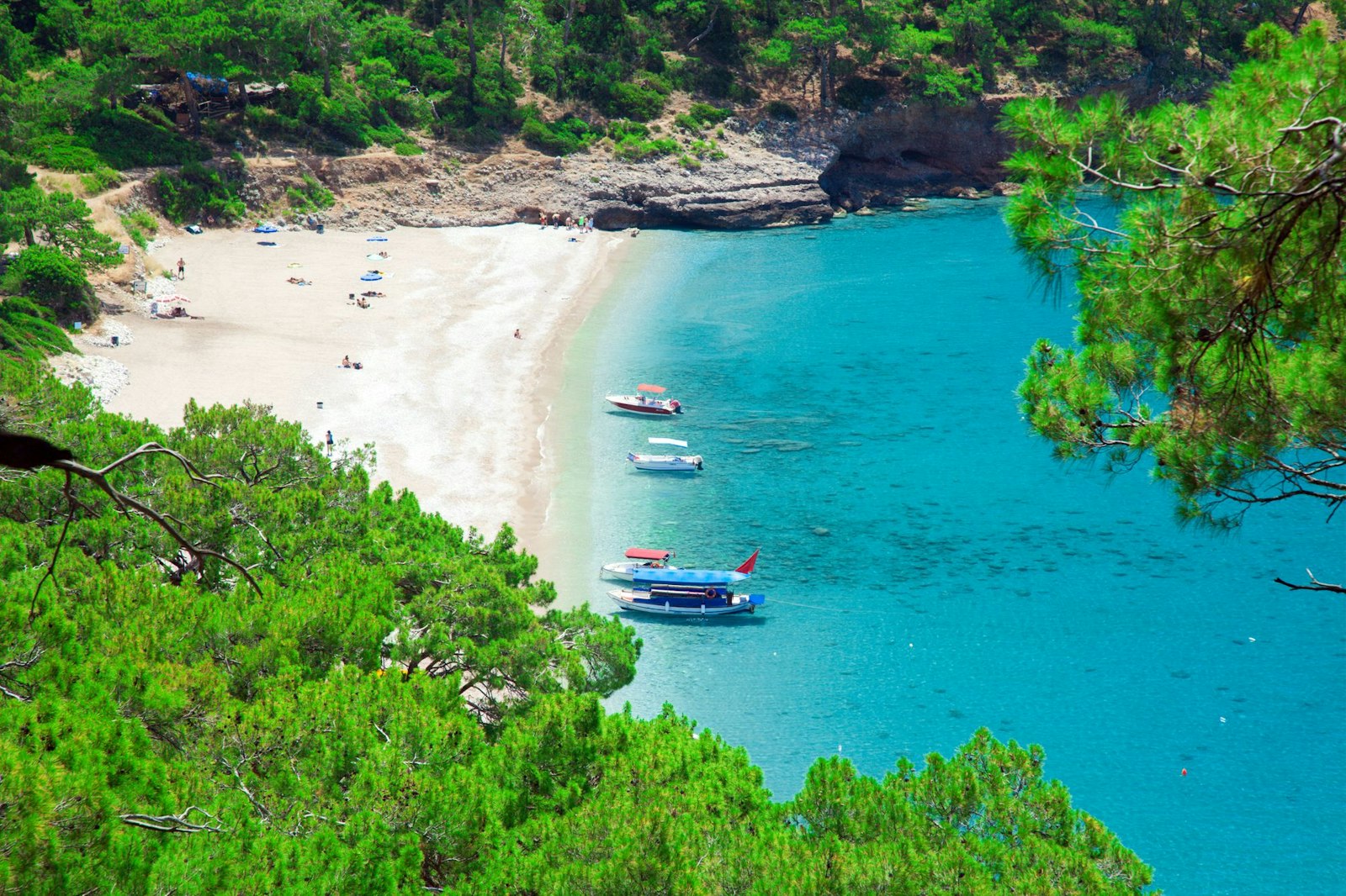Kabak Koyu'nun turkuaz suları ve çam ormanlarıyla çevrili ince kumlu plajı