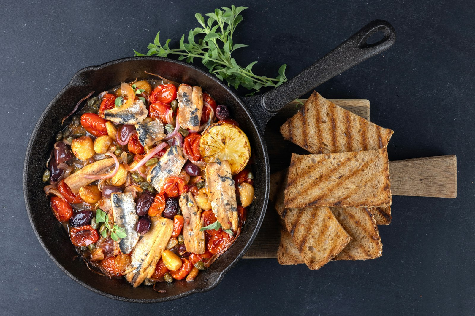 Sicilian style dish with sardines, cherry tomatoes, olives, capers, red onion, garlic and grilled lemon.