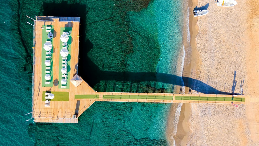 Aerial view of the pier and sunbed deck by the sandy beach at Bera Alanya Resort
