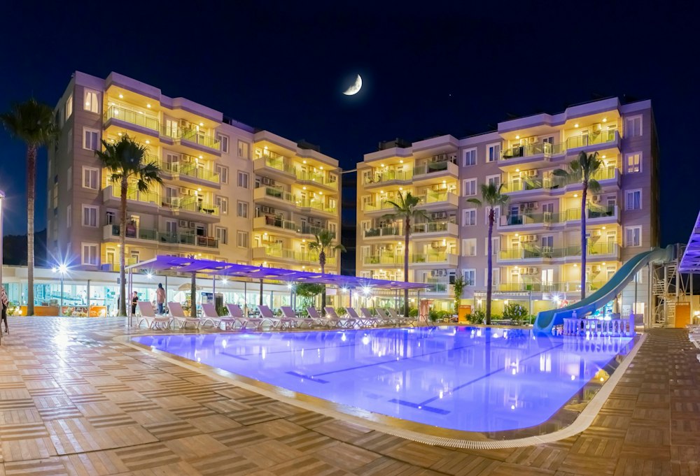 Grand Akça Resort at night, with the lit pool and a water slide in front of the hotel