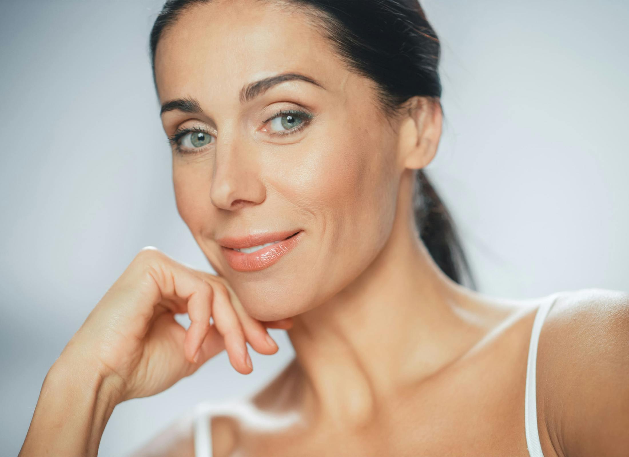 woman smiling with her hand under her chin
