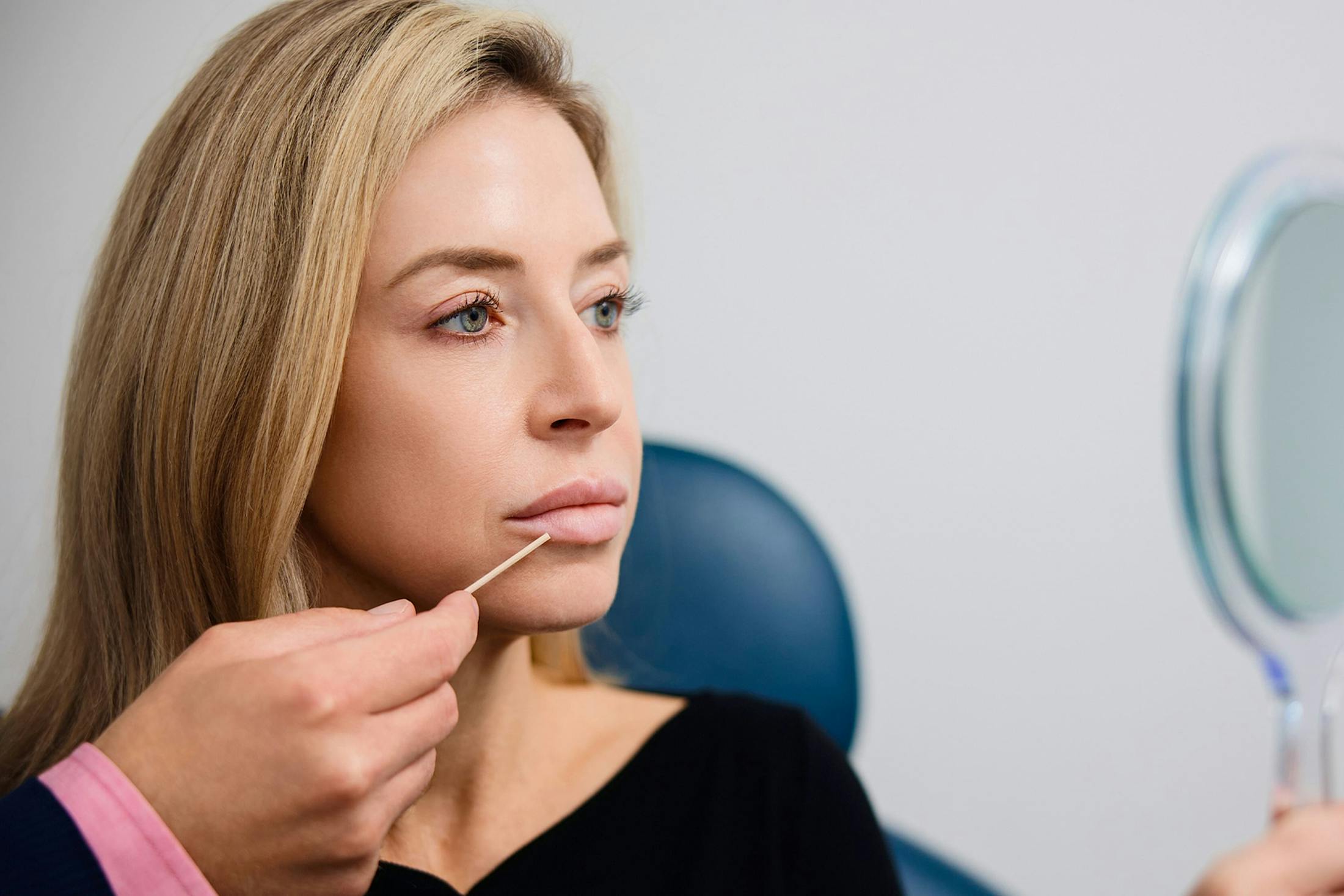female patient getting his lips examined