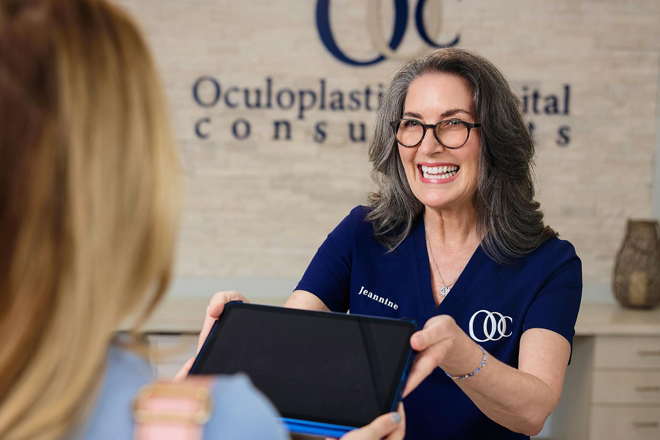 Receptionist handing ipad to patient