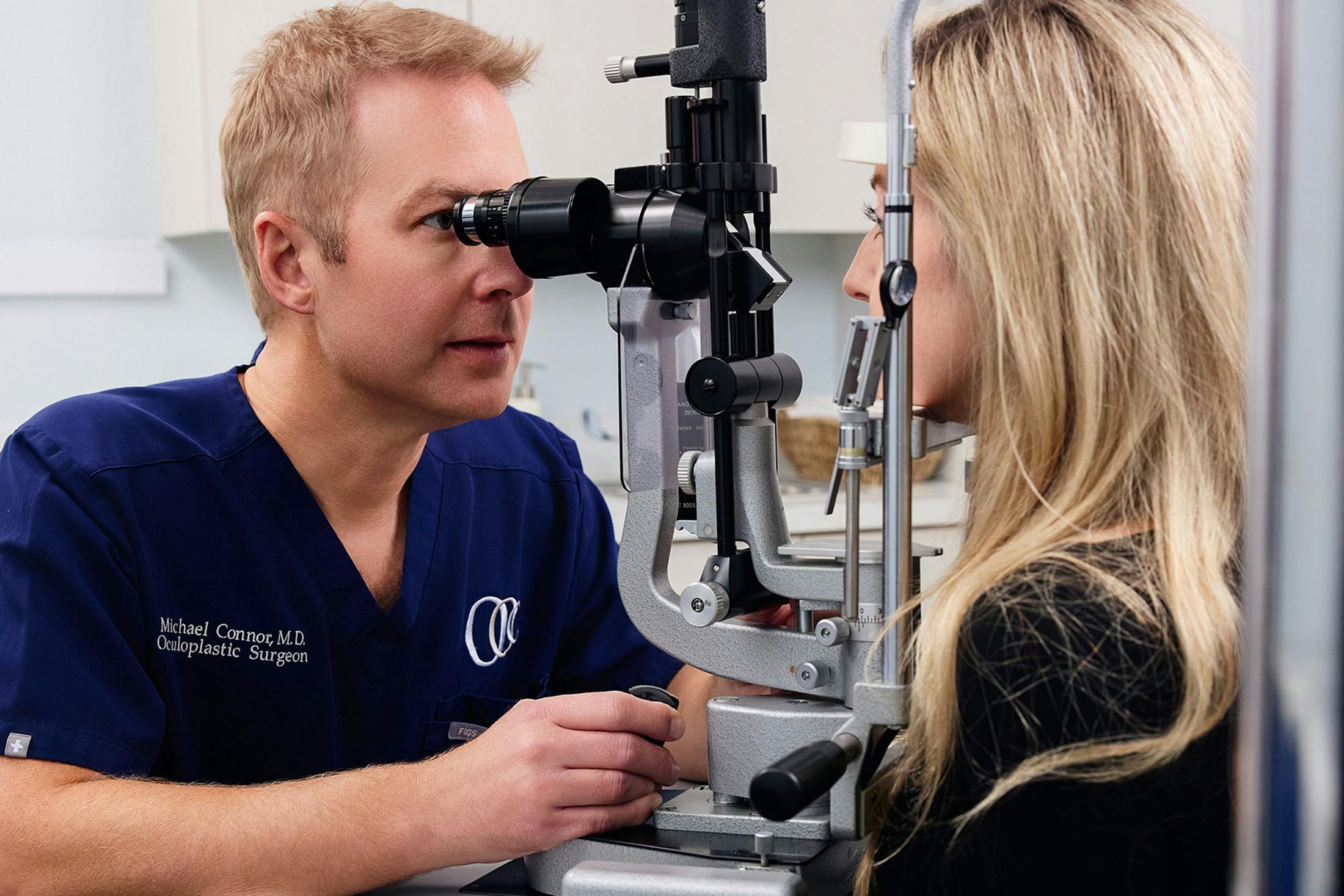 Dr. Connor looking at patients eyes through a machine