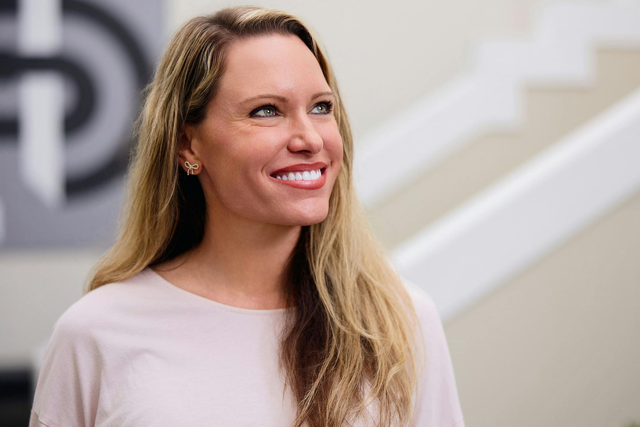 woman smiling wearing a pink shirt