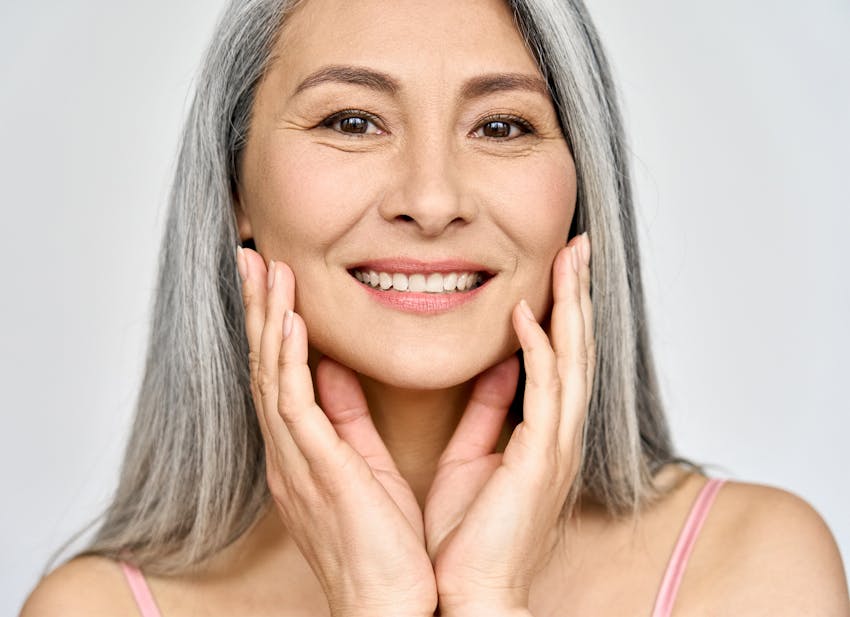 older woman touching her cheeks
