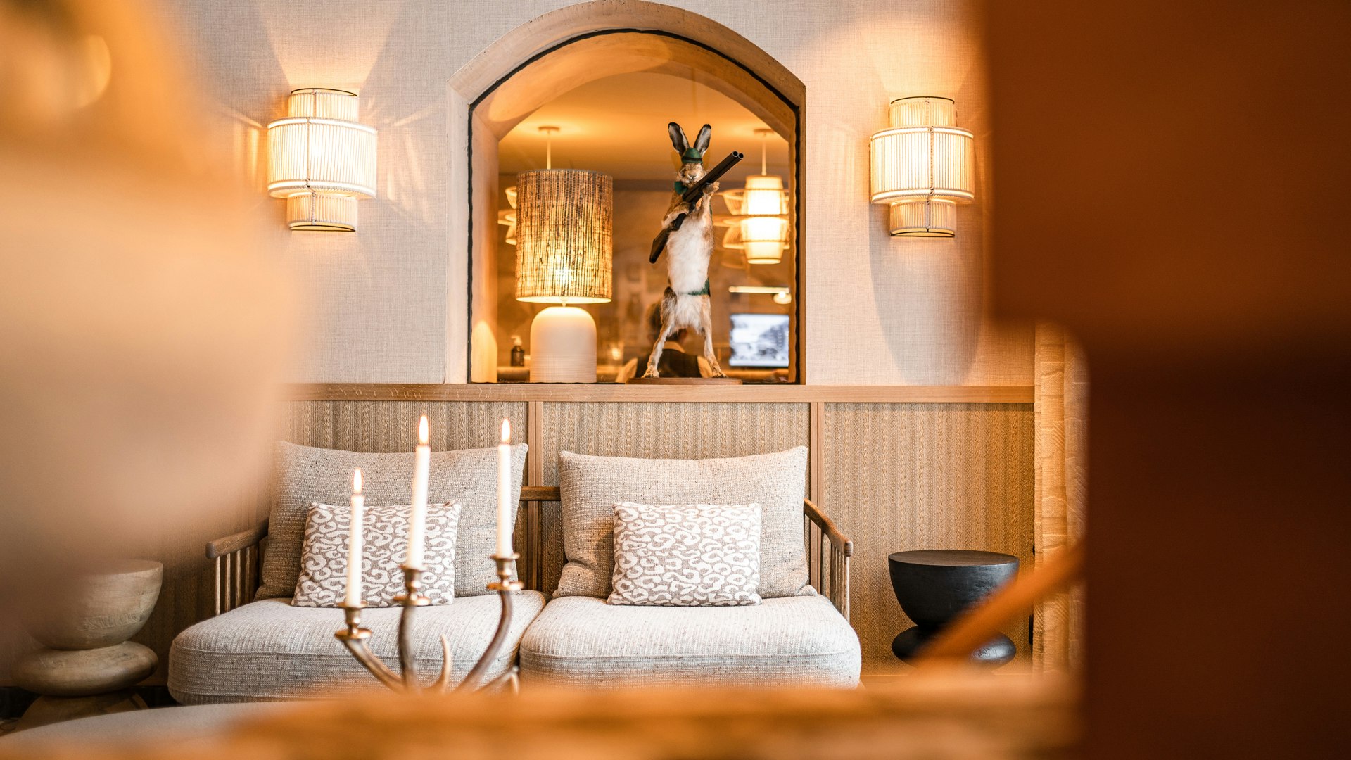 Gemütliche Lounge mit Sesseln, Kerzen und dekorativem Hasen.