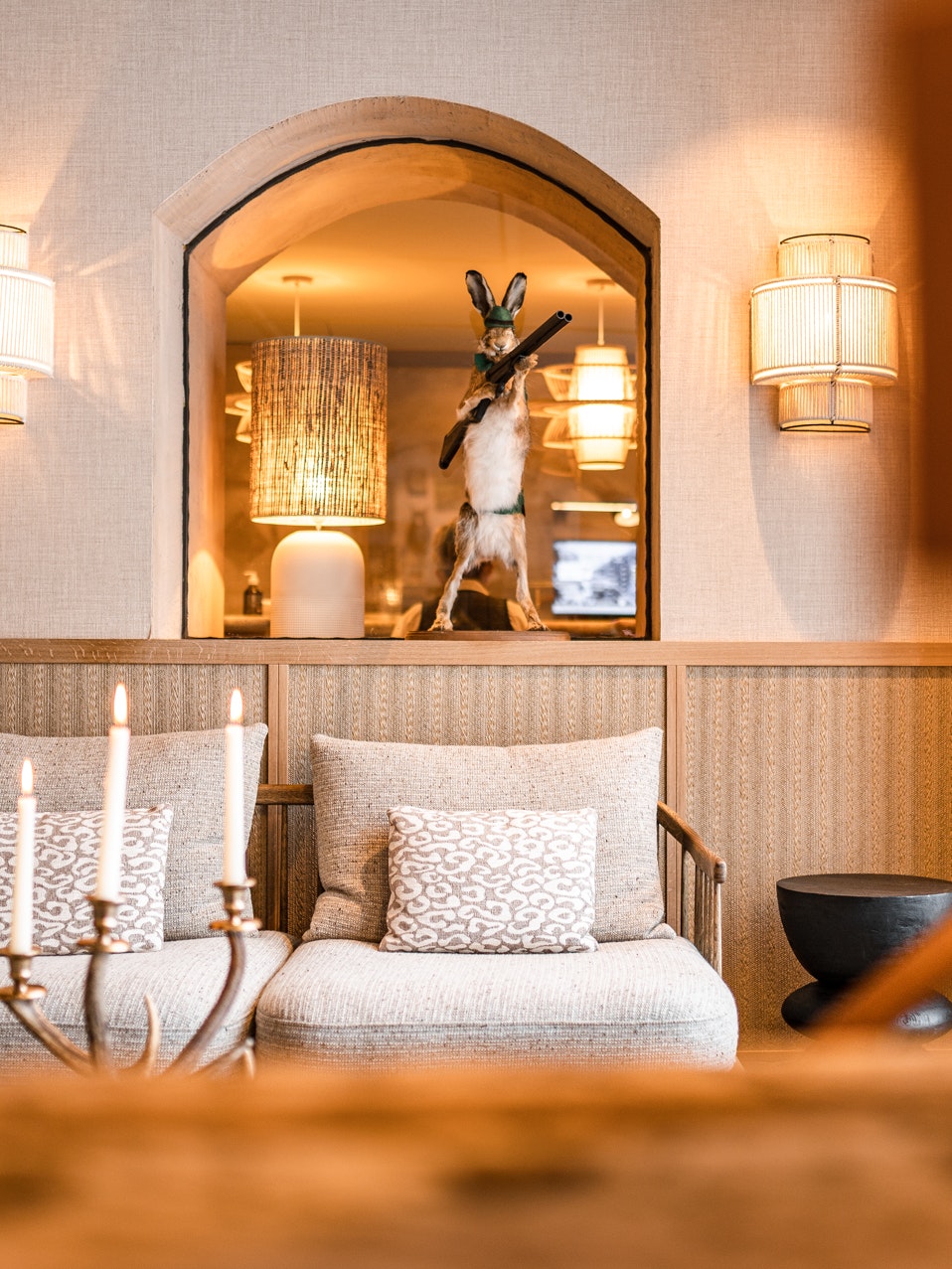 Gemütliche Lounge mit Sesseln, Kerzen und dekorativem Hasen.