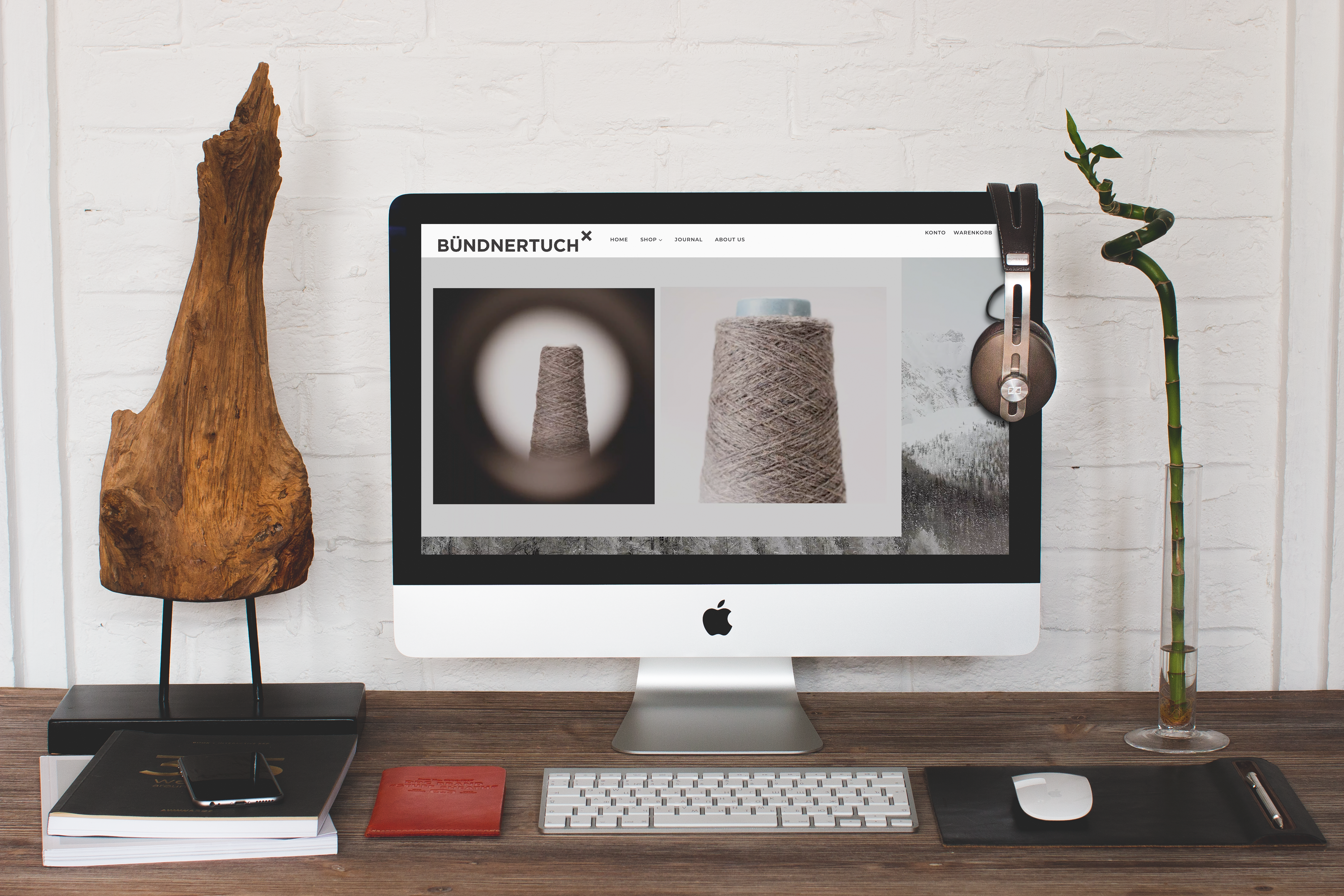 Schreibtisch mit iMac und Bündnertuch-Webseite.