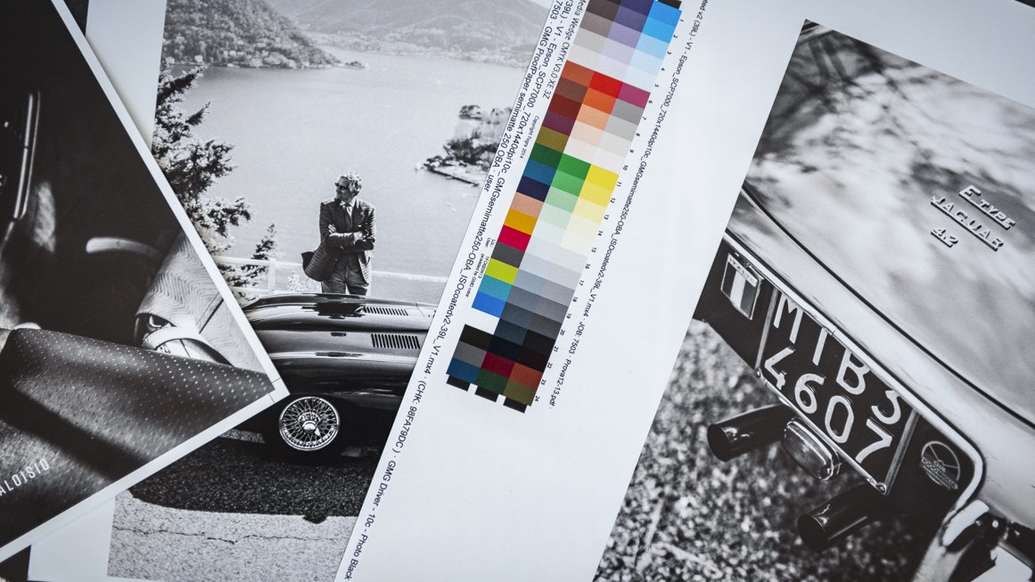 Druckbögen mit Schwarz-Weiß-Fotos klassischer Autos und einer Farbskala für den finalen Buchdruck.