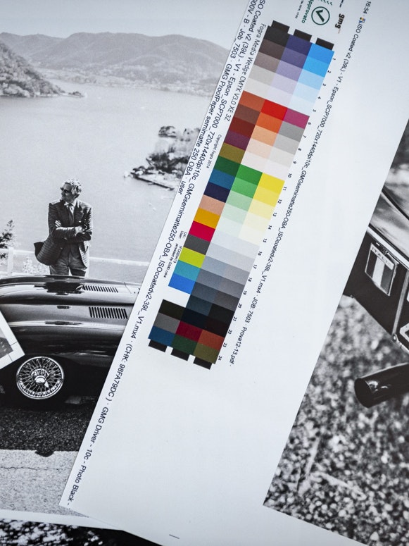 Druckbögen mit Schwarz-Weiß-Fotos klassischer Autos und einer Farbskala für den finalen Buchdruck.