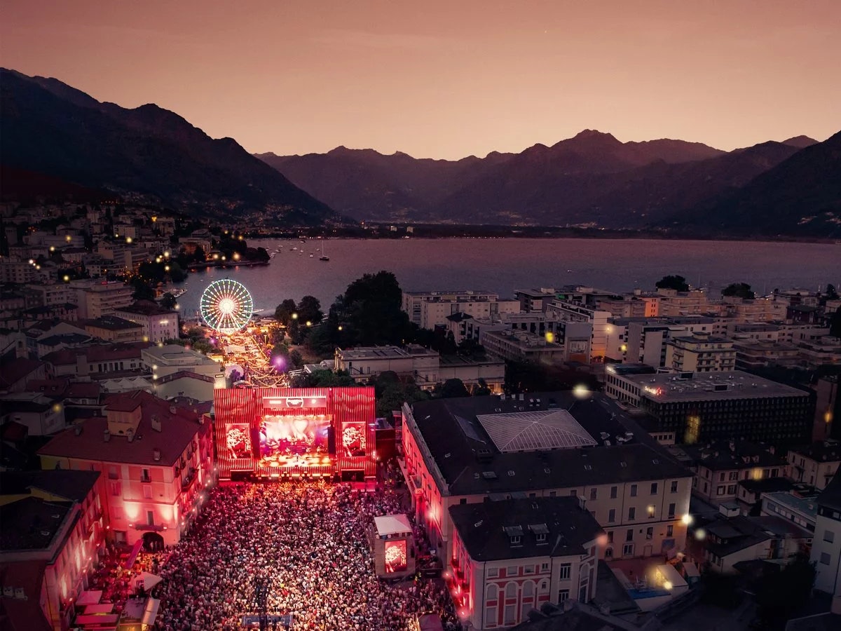 Evening view of Locarno with a festival stage, large crowd, and the lake in the background.