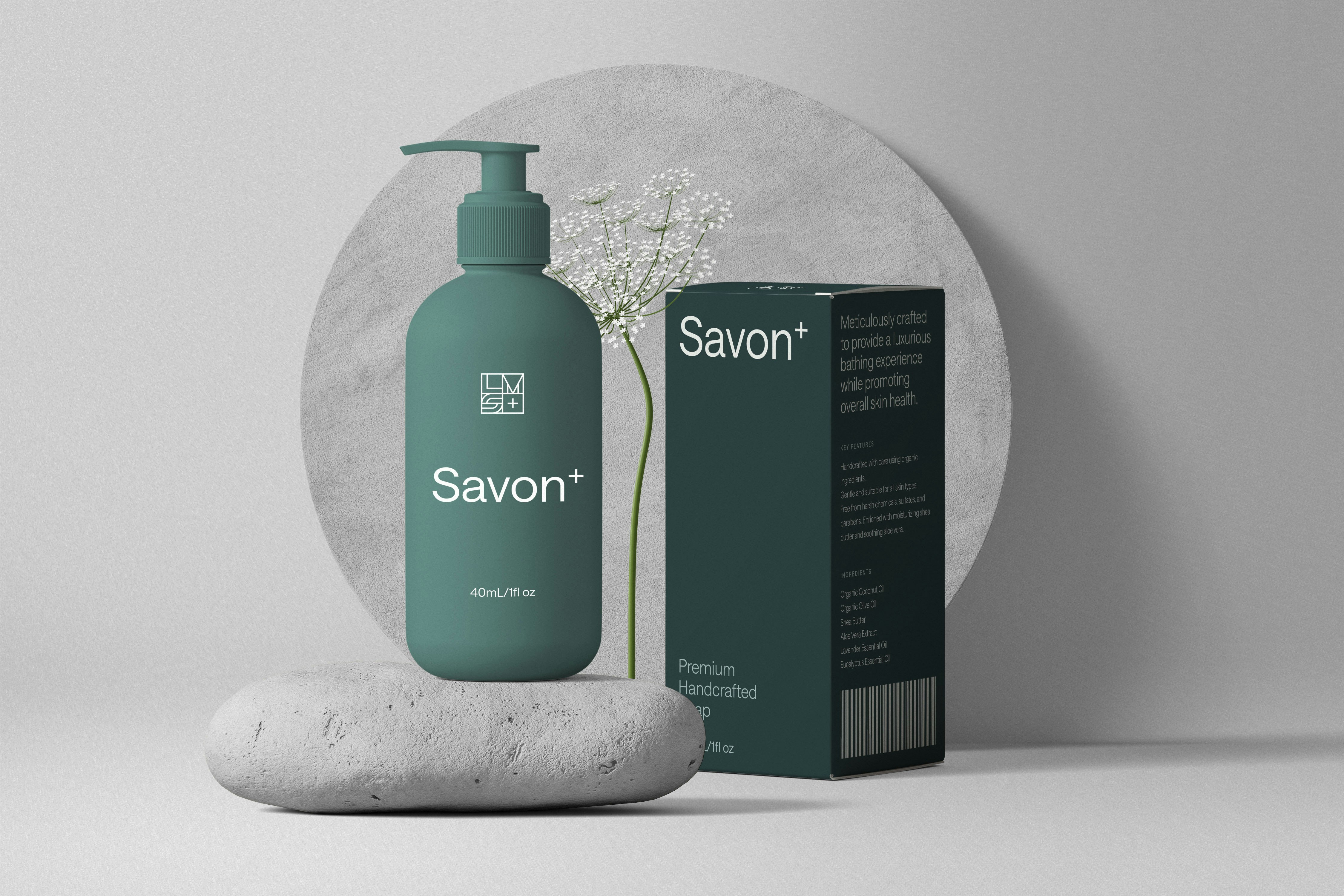 Elegantes Produktfoto einer Savon+ Seifenflasche mit passender Verpackung, stilvoll inszeniert auf Stein mit zartem Blumenstiel.