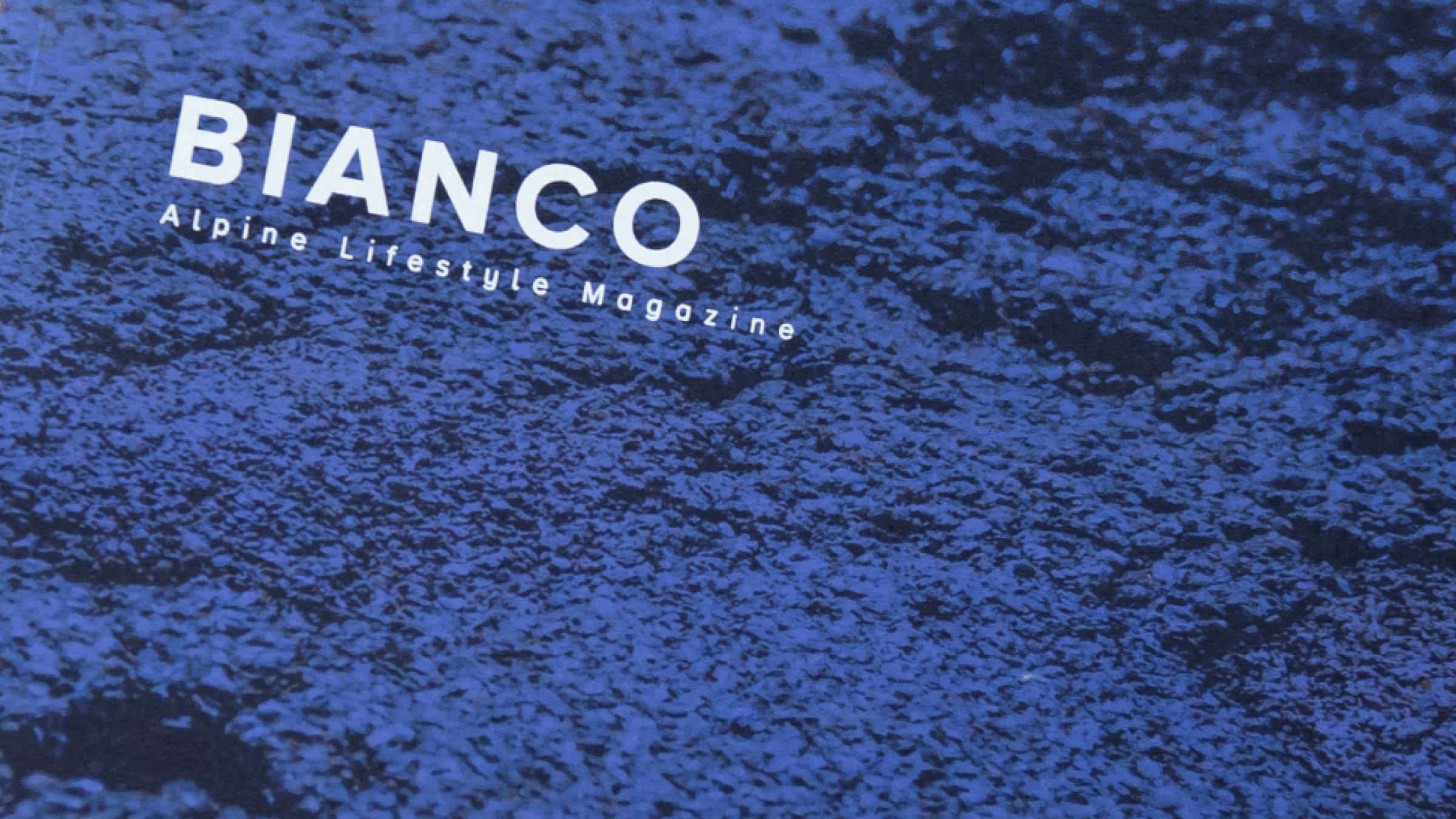 Magazin-Cover „BIANCO – Alpine Lifestyle Magazine“ mit markantem blauen Texturhintergrund