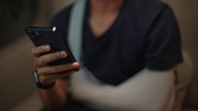 A man with broken arm on his phone