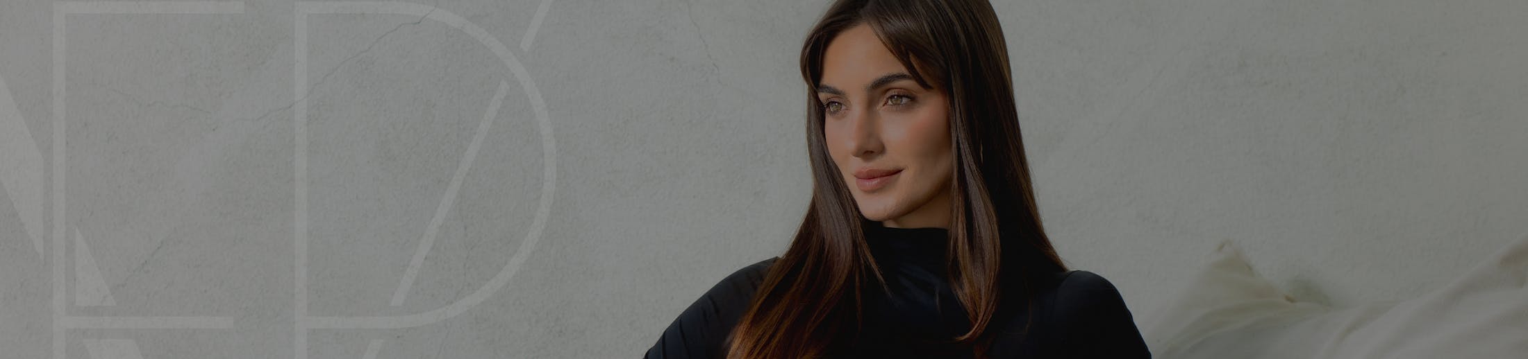 woman with long brown hearing wearing a long sleeve black shirt