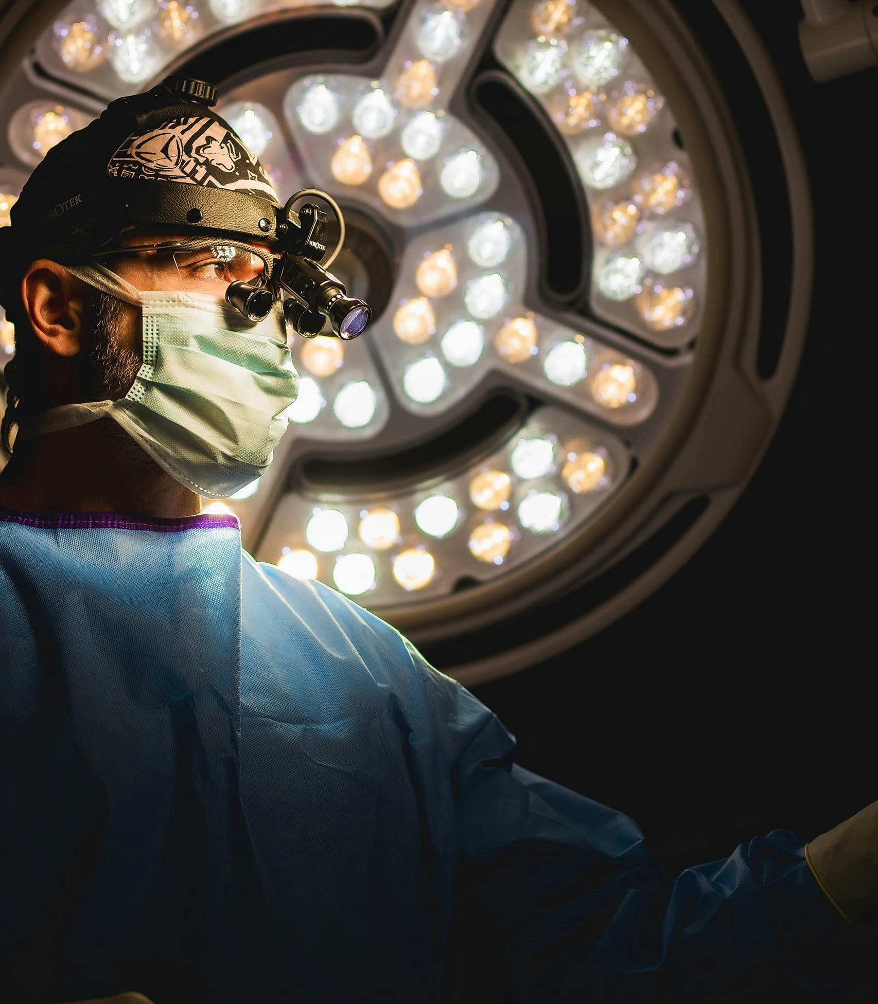 doctor wearing surgery equipment infront of a big light
